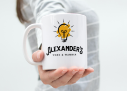 Alexander's Work and Wander Coffee Mug held out in lady's hand