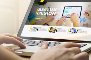 Laptop being used showing person's hands with bestsite that says