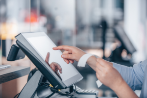 Hand typing on Point of Sale Screen